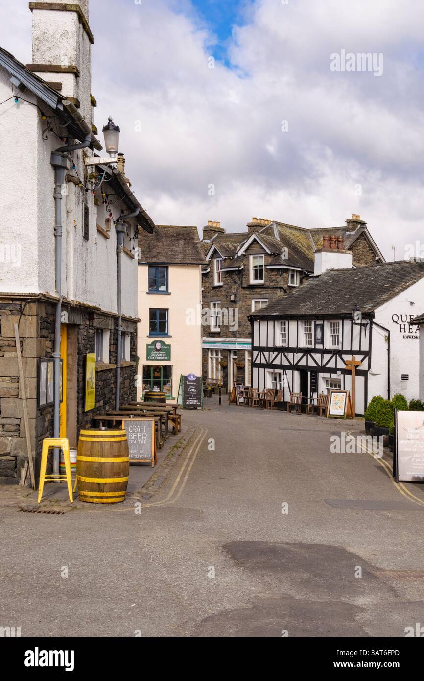 View along narrow street to Queens Head village pub in Lake District National Park. Hawkshead, Cumbria, England UK, Britain. Stock Photo