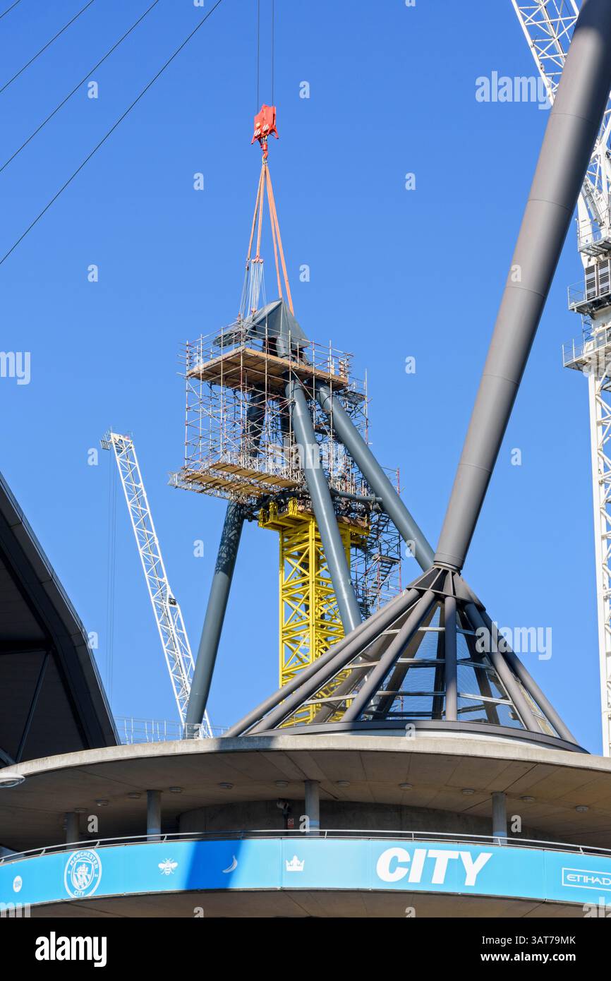 Etihad stadium North Stand expansion.  One of the support towers for the roof support cables.  Manchester, England, UK.  Cap being lifted into place. Stock Photo