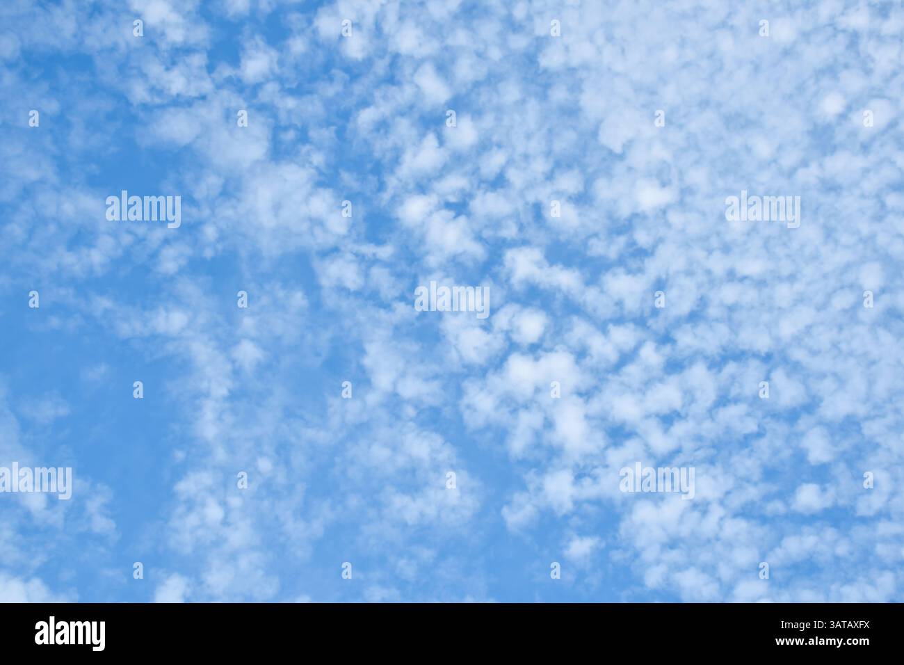 White fluffy patchy clouds on blue sky Stock Photo