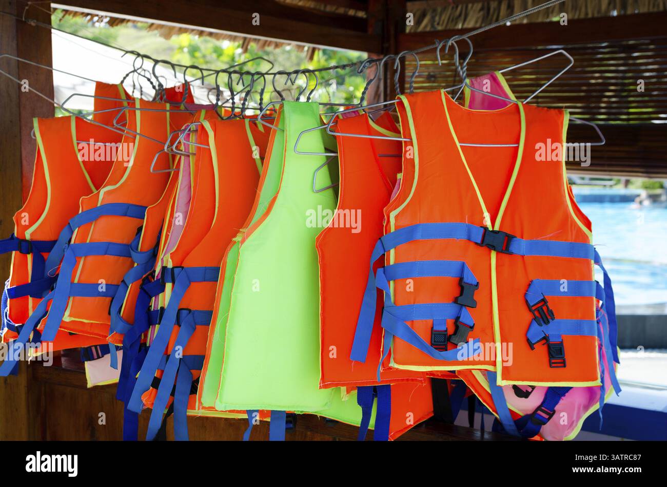 Orange life jackets for rent at hotel swimming pool Stock Photo - Alamy
