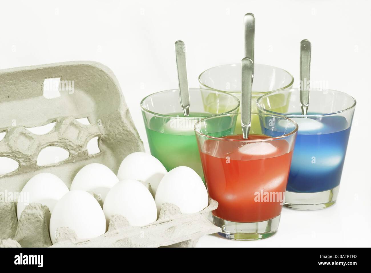 Easter eggs in a jar with food colouring Dyeing colourful Easter eggs on bright Background Stock Photo