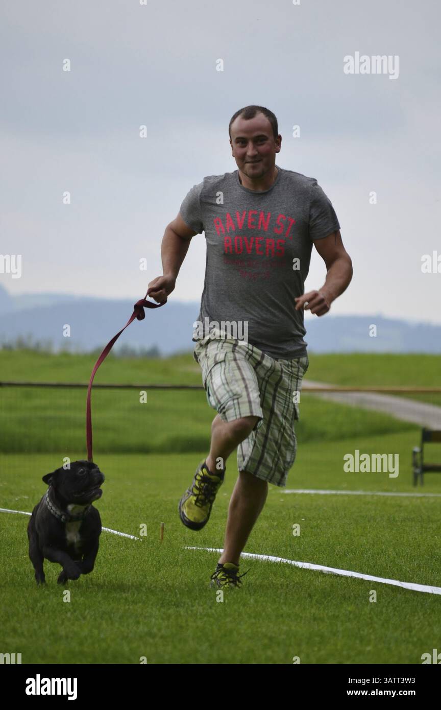 Man runs with French Bulldog Stock Photo
