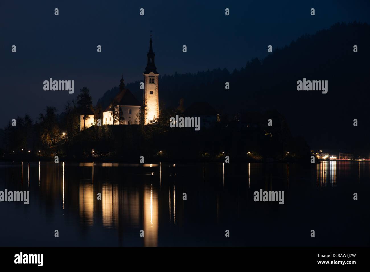 Assumption of mary pilgrimage church on bled island reflecting on lake bled at night. Slovenia, Europe Stock Photo