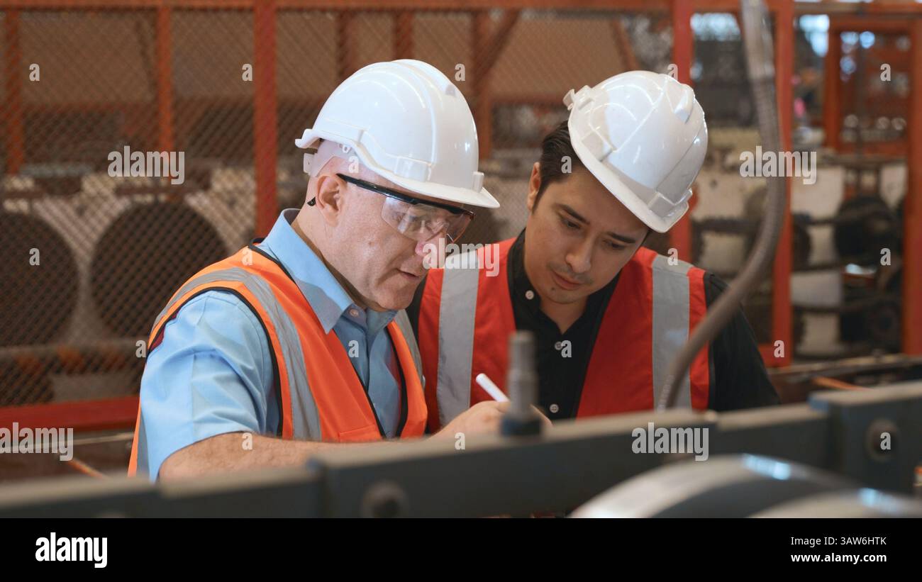 Engineer teaching apprentice to use metal sheet stamping machine Stock Photo