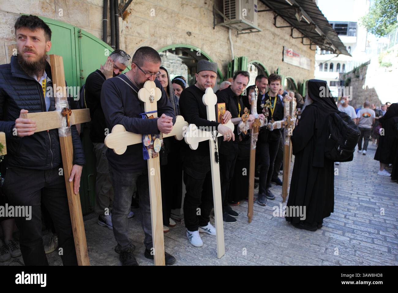 Serbian Orthodox pilgrims holding ornamented crosses & icons wait on ...