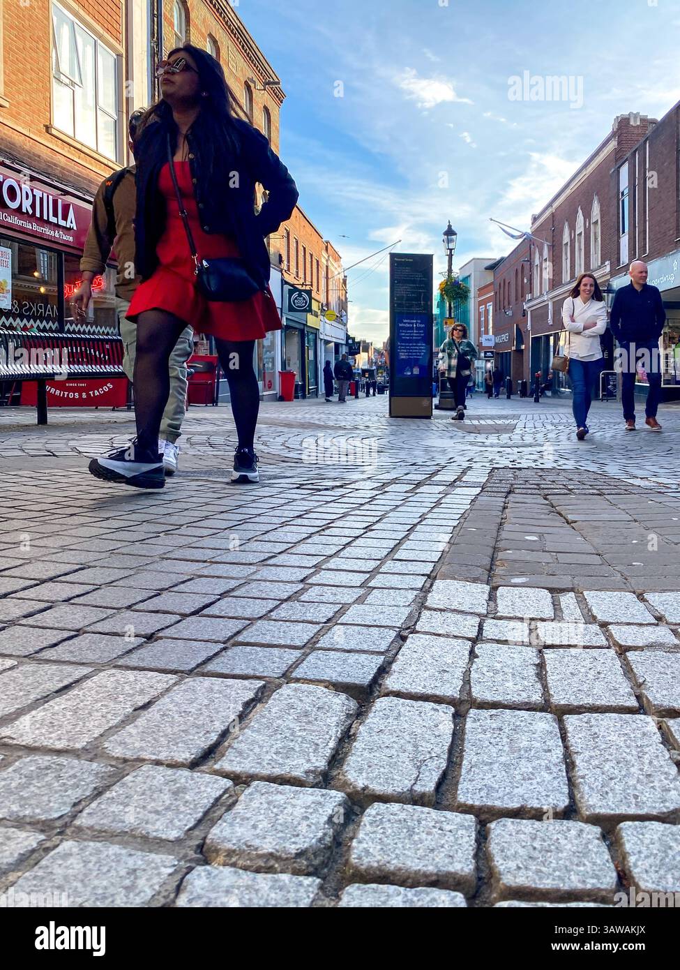 Low angle shot of people hurrying about their business on Peascod Street in Windsor, Berkshire, UK - Smartphone Captured Stock Image