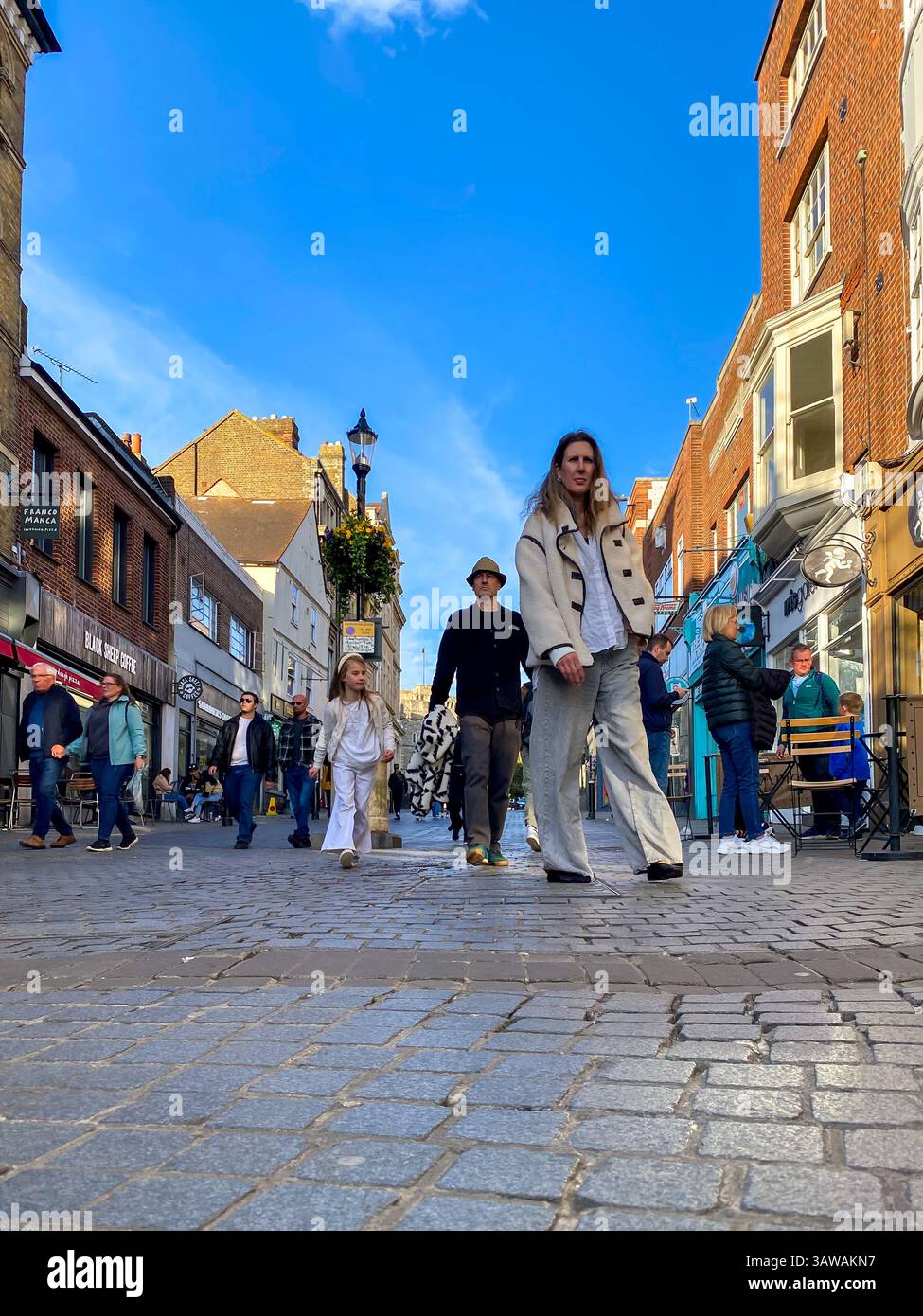 Low angle shot of people hurrying about their business on Peascod Street in Windsor, Berkshire, UK - Smartphone Captured Stock Image
