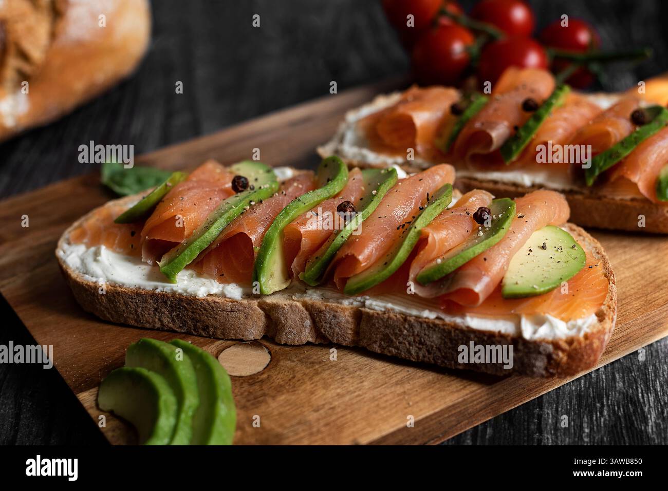Une tranche de pain au levain, de l'avocat, du saumon et du fromage frais. Un délice pour le brunch du dimanche, pour un repas rapide ou sur le pouce. Stock Photo
