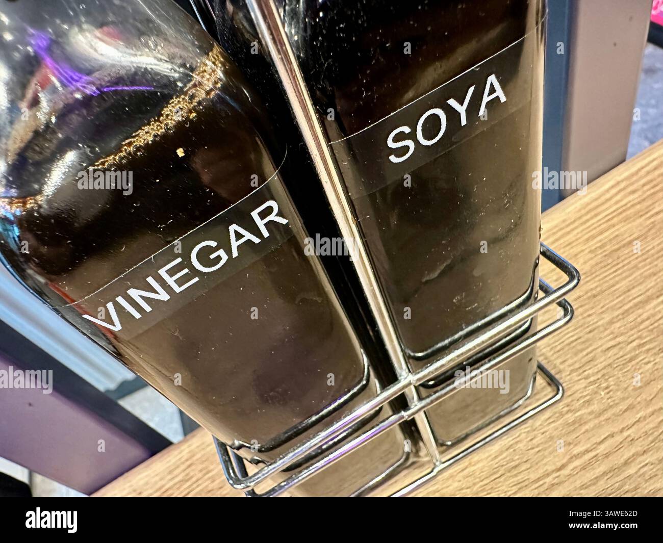 Two bottles of condiments on a table of a Chinese pulled noodle restaurant: soya sauce and vinegar - Smartphone Captured Stock Image