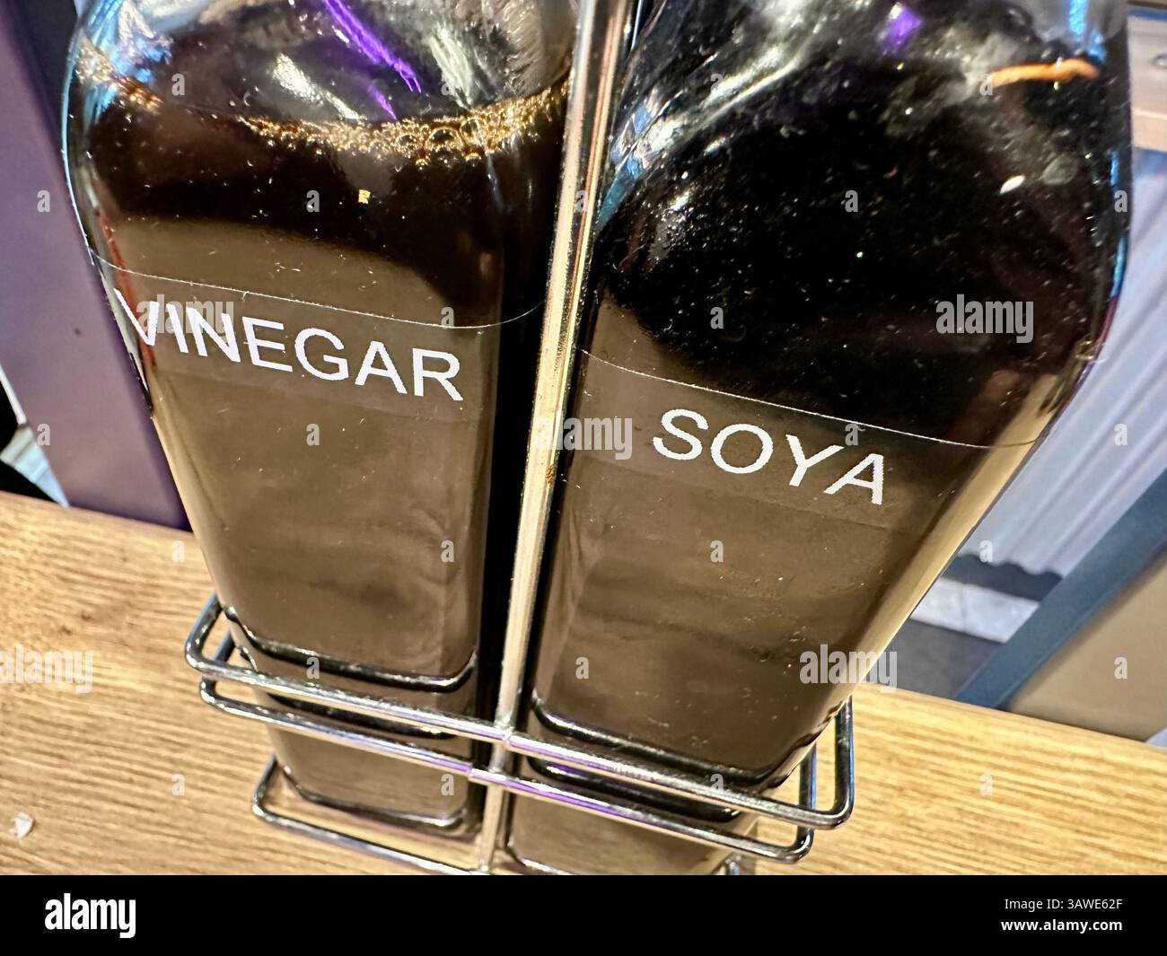 Two bottles of condiments on a table of a Chinese pulled noodle restaurant: soya sauce and vinegar - Smartphone Captured Stock Image