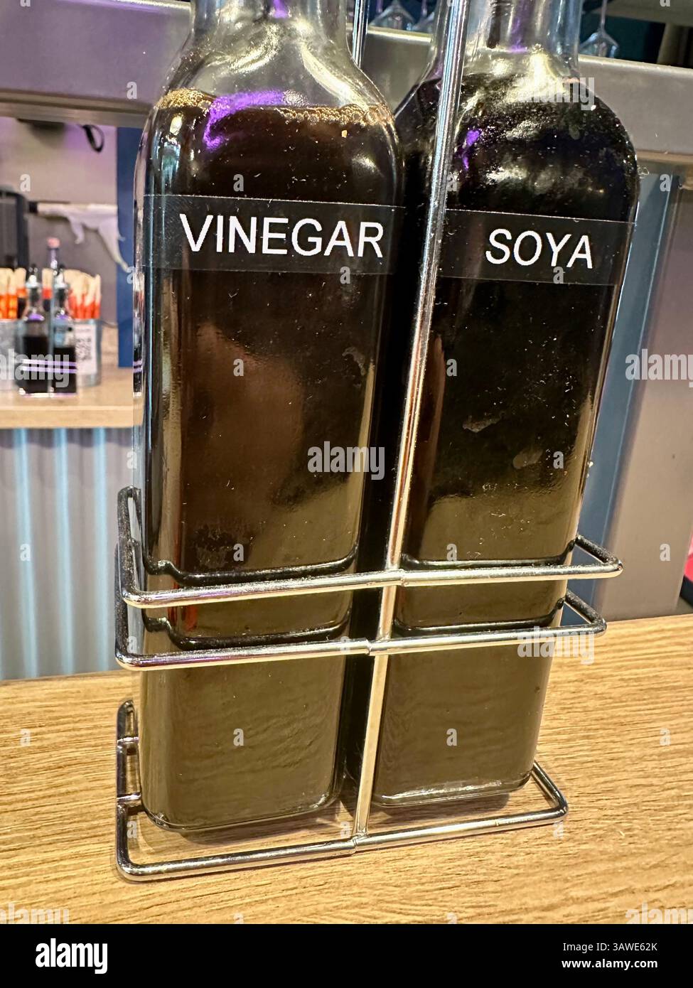 Two bottles of condiments on a table of a Chinese pulled noodle restaurant: soya sauce and vinegar - Smartphone Captured Stock Image