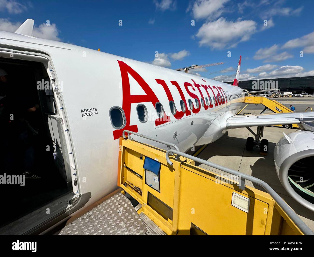 The outside of a A320 airbus with the logo of Austrian airways on the outside at Vienna airport - Smartphone Captured Stock Image