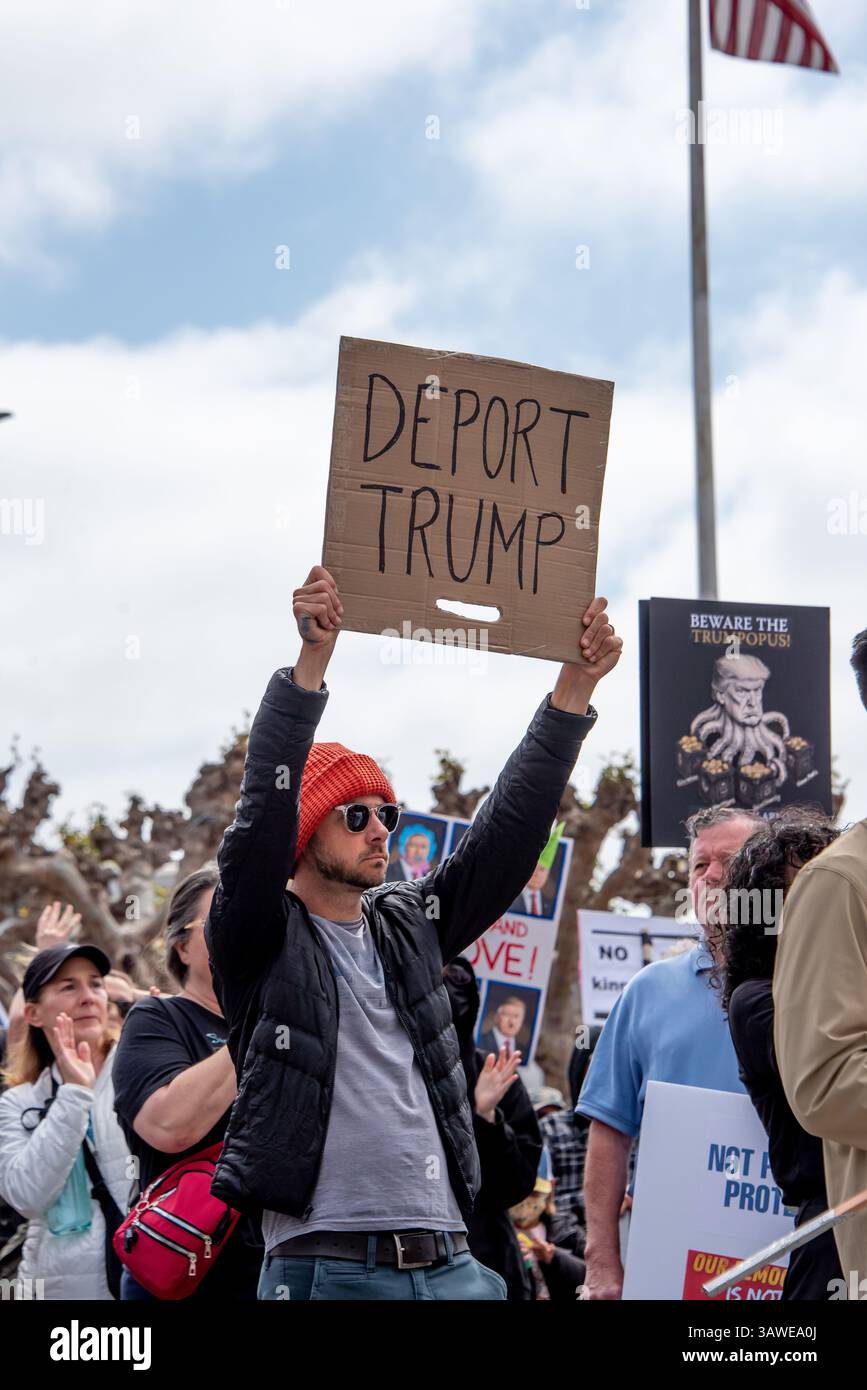 San Francisco, USA. 19th Apr 2025. A young man protester holds a sign reading, 'Deport Trump' at the Civic Center Plaza “Stop the Billionaire Agenda” protest against the Trump Administration. Credit: Shelly Rivoli/Alamy Live News - Stock Image