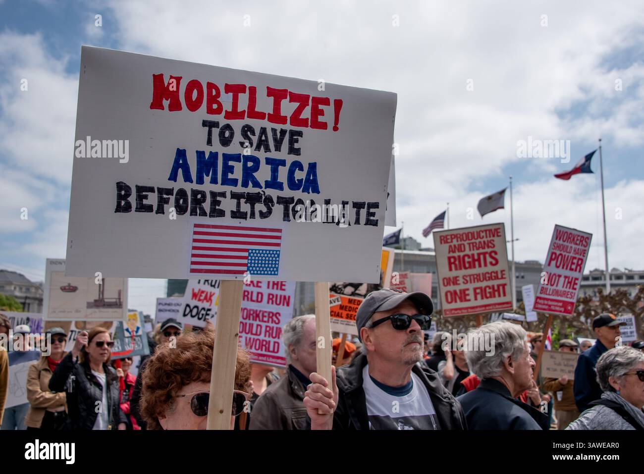 San Francisco, USA. 19th Apr 2025. Protesters crowd Civic Center Plaza for the “Stop the Billionaire Agenda” protest against the Trump Administration. Many signs are seen among the crowd, incluing ones reading, 'Mobilize! to save America before it's too late,' 'Reproductive and trans rights, one struggle, one fight.' Credit: Shelly Rivoli/Alamy Live News - Stock Image