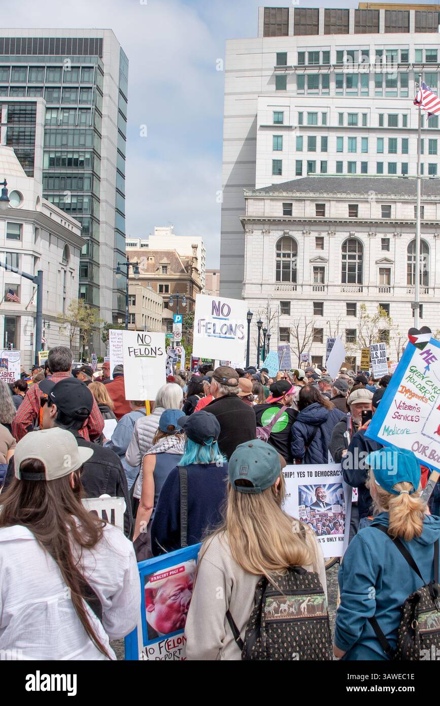 San Francisco, USA. 19th Apr 2025. Acrowd of protesters fills Civic Center Plaza for the “Stop the Billionaire Agenda” protest against the Trump Administration. Above the people and many signs, two signsare held high reading, 'No felons.'  Credit: Shelly Rivoli/Alamy Live News - Stock Image