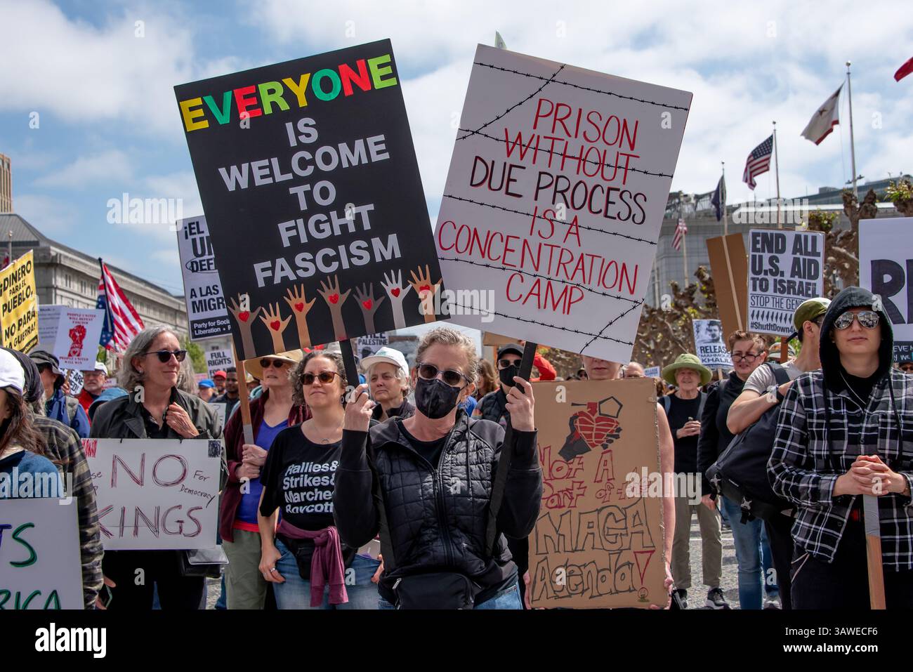 San Francisco, USA. 19th Apr 2025. At Civic Center Plaza.a crowd of protesters gather for the “Stop the Billionaire Agenda” protest against the Trump Administration. Several signs are seen among the crowd, with two at the front reading, 'Everyone is welcome to fight fascism,' and 'Prison without due process is a concentration camp.' Credit: Shelly Rivoli/Alamy Live News - Stock Image