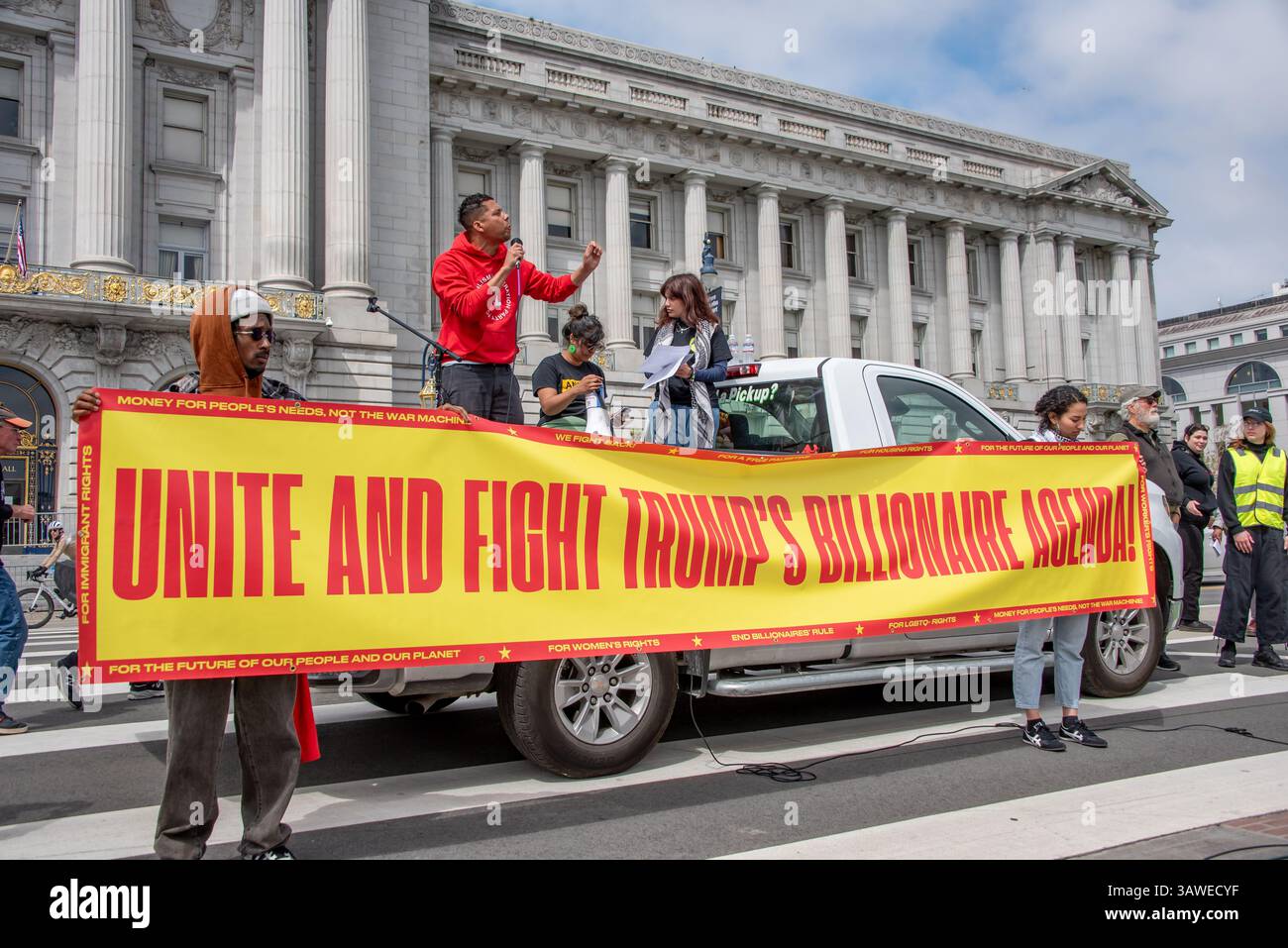 San Francisco, USA. 19th Apr 2025. A passionate speaker addresses the crowd of protesters gathered at Civic Center Plaza for the “Stop the Billionaire Agenda” protest against the Trump Administration. in front of him, demonstrators hold a wide banner for the event reading, 'Unite and Fight Trump's Billionaire Agenda!' Credit: Shelly Rivoli/Alamy Live News - Stock Image