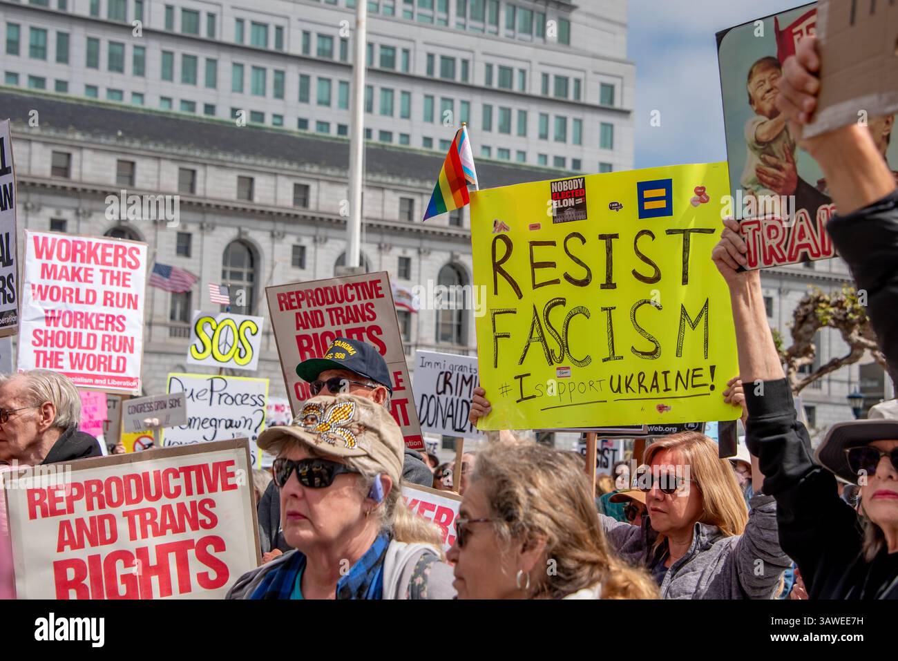 San Francisco, USA. 19th Apr 2025. At Civic Center Plaza's “Stop the Billionaire Agenda” protest against the Trump Administration, a woman is seen among the crowd holding a sign reading, 'Resist Fascism. I support Ukraine!' Credit: Shelly Rivoli/Alamy Live News - Stock Image