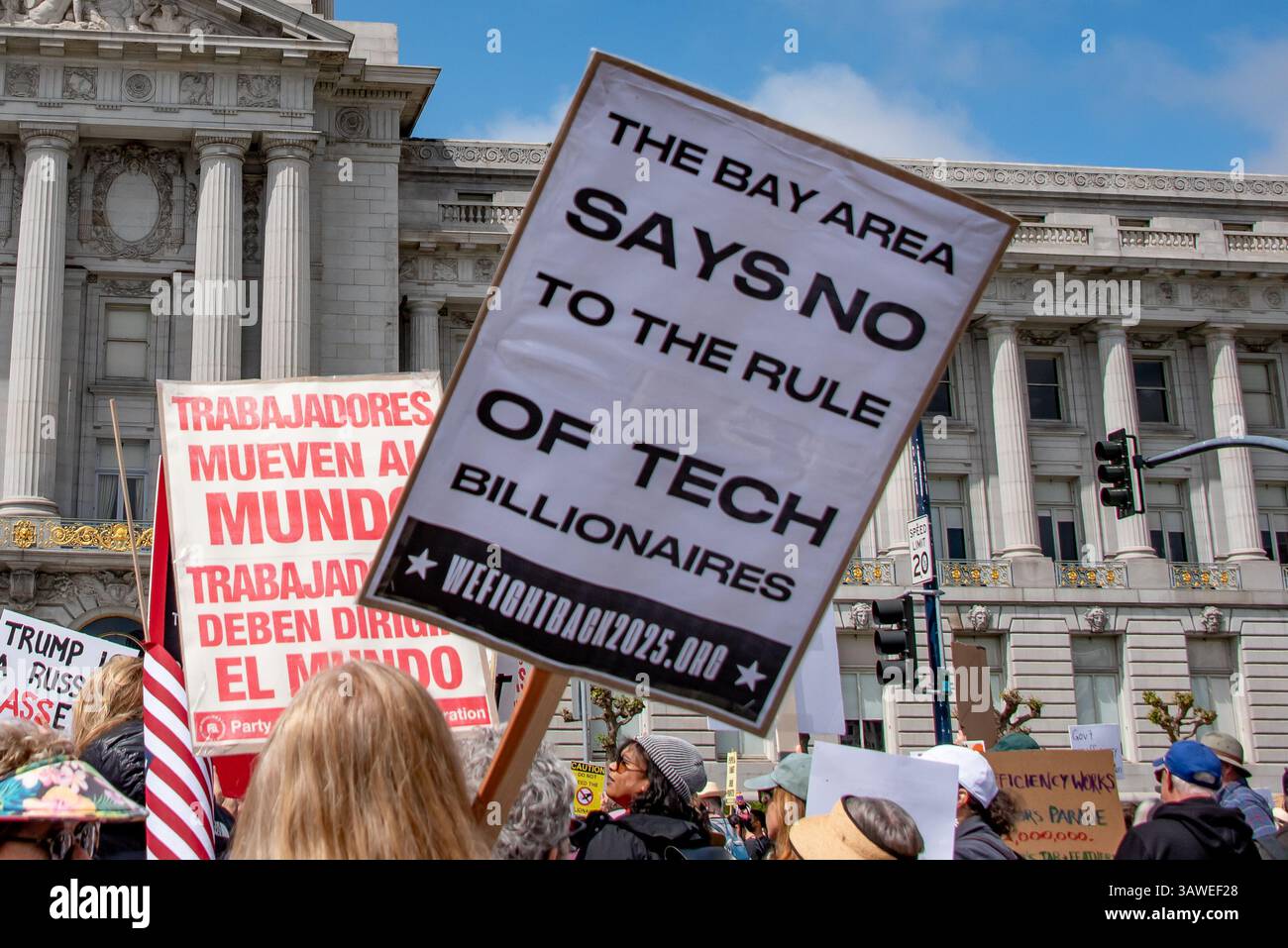 San Francisco, USA. 19th Apr 2025. In front of San Francisco City Hall during the “Stop the Billionaire Agenda” protest against the Trump Administration, a protest sign held high reads, 'The Bay Area says no to the rule of tech billionaires.'  Credit: Shelly Rivoli/Alamy Live News - Stock Image