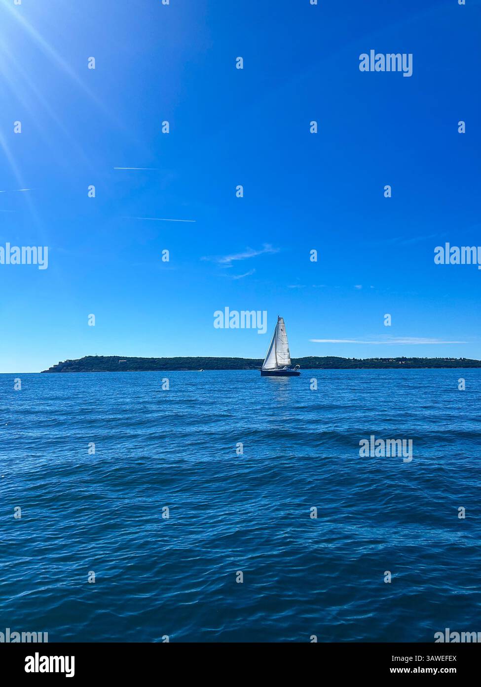 Elegant sailing ship glides past the Prevlaka Peninsula at the stunning Bay of Kotor entrance. - Smartphone Captured Stock Image