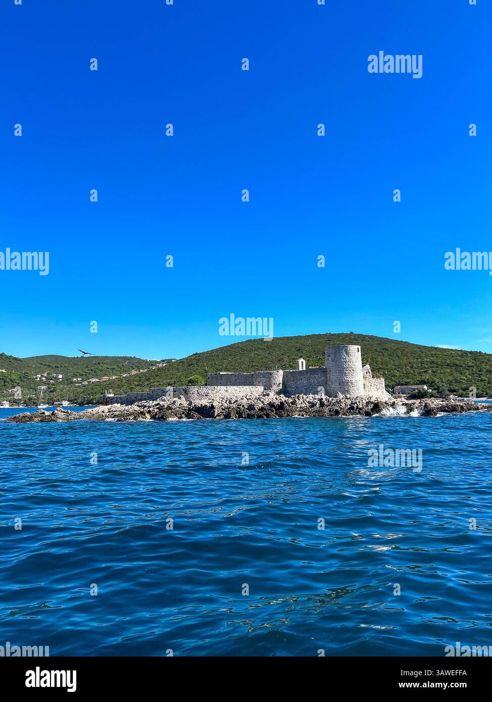 Historic Arza Fortress sits by the brilliant blue Adriatic Sea at the Bay of Kotor's entrance. - Smartphone Captured Stock Image