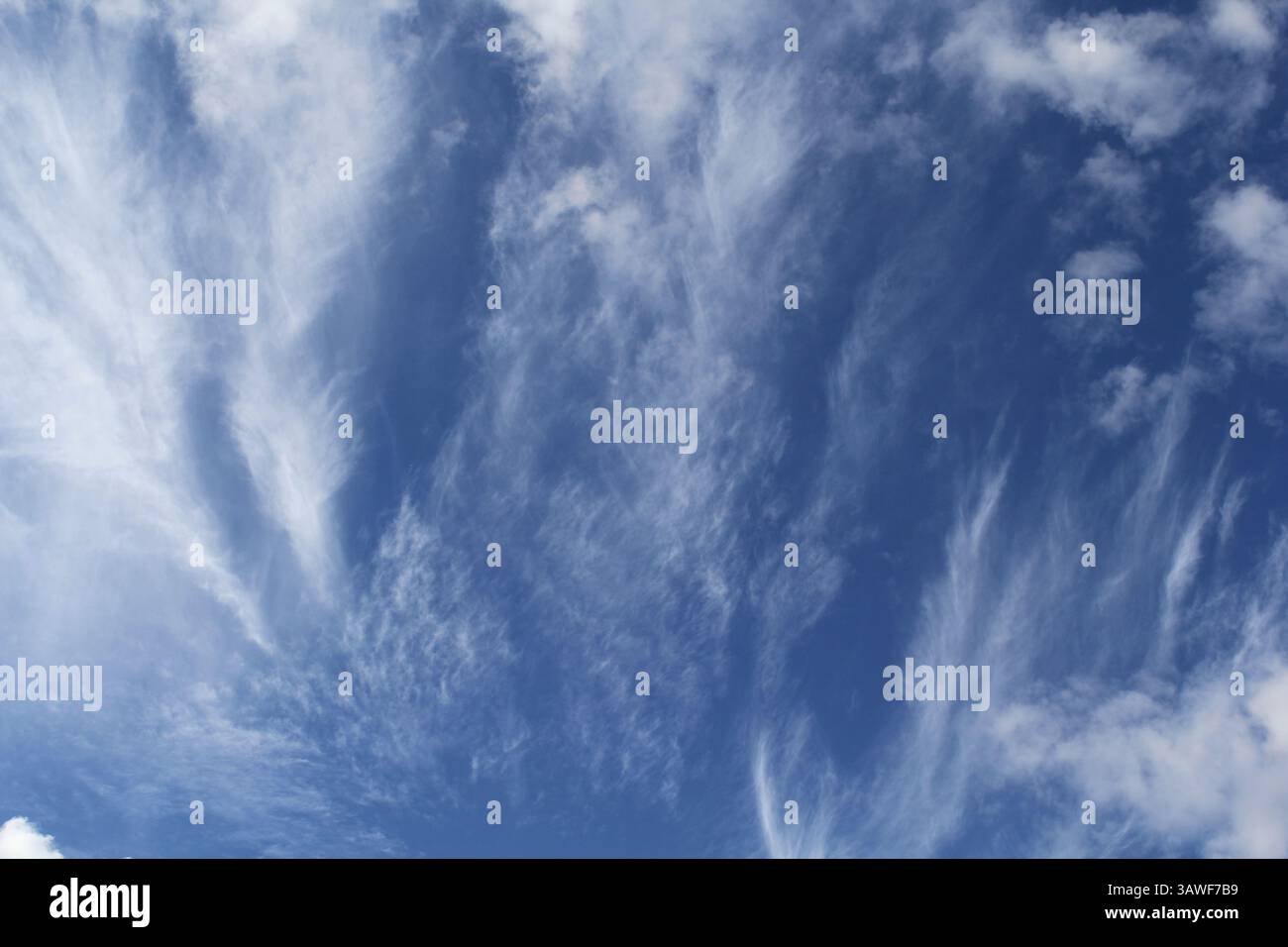 Blue sky with wispy white clouds Stock Photo - Alamy