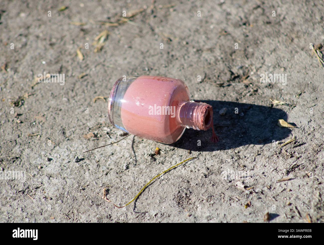 pink nail polish left on ground Stock Photo