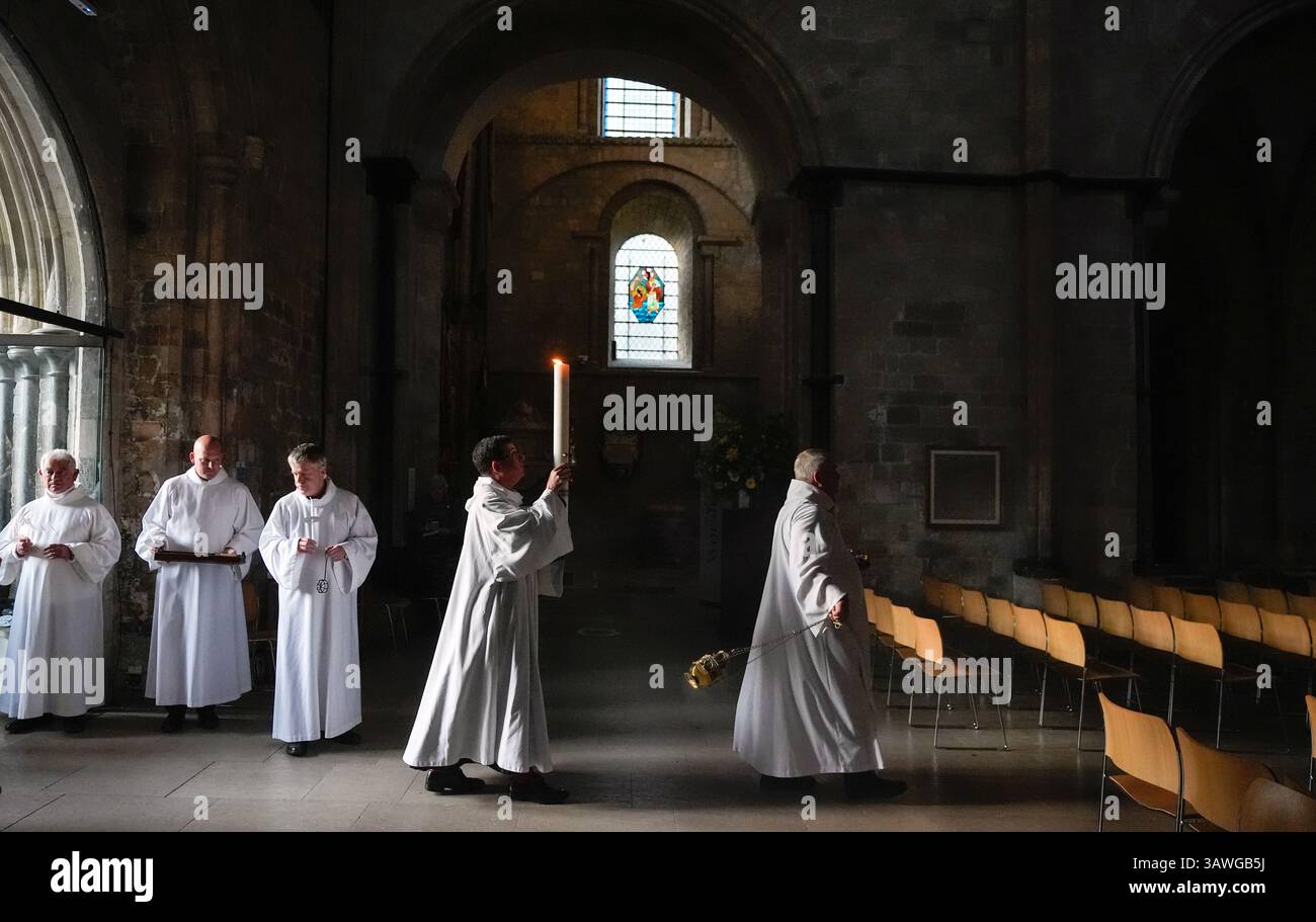 The Dean of Chichester Cathedral, The Very Reverend Dr Edward Dowler (2nd right) carries the Paschal Candle into Chichester Cathedral after it was lit in a ceremony ahead of the Easter Vigil. Picture date: Saturday April 19, 2025. Stock Photo