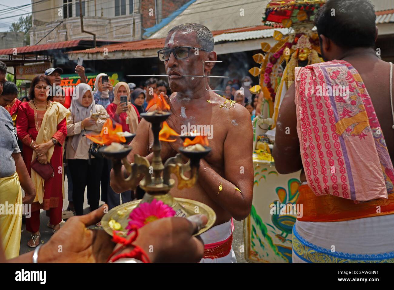 Banda Aceh, Aceh, Indonesia. 20th Apr, 2025. A Hindu devotee is seen with his mouth pierced with metal items during a procession during the Thaipusam series at the Shri Palani Andawer Temple, Banda Aceh City, Aceh province, Indonesia on Sunday, April 20, 2025.The annual Hindu Festival, mostly celebrated by the Tamil community in honour of The Hindu god Lord Murugan, remains in full swing in the Muslim-majority region with high tolerance. Credit: Khairu Syukrillah/ZUMA Press Wire/ZUMA Wire/Alamy Live News Stock Photo