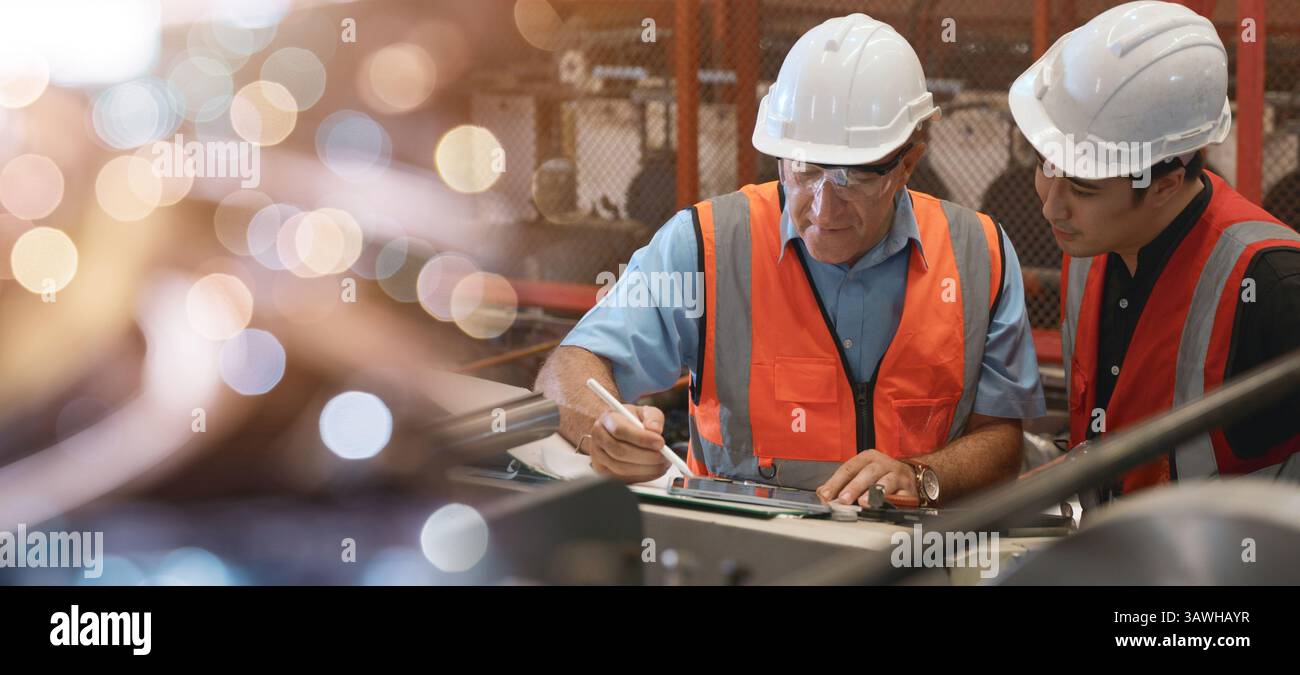 Engineer teaching apprentice to use metal sheet stamping machine Stock Photo
