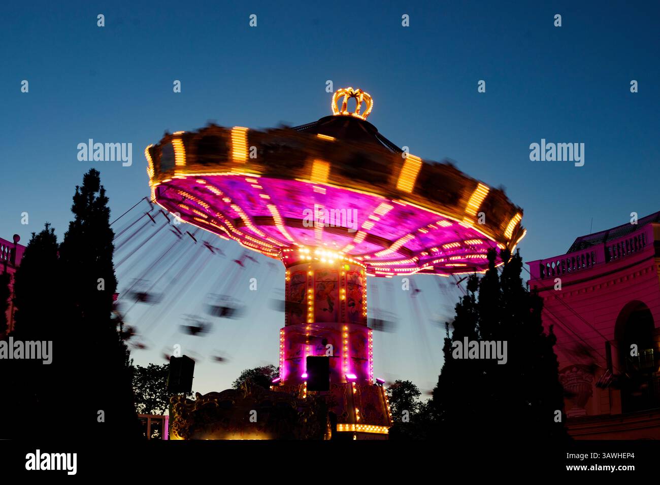 AUSTRIA, VIENNA, 20250419; An illuminated carousel spins in the evening ...
