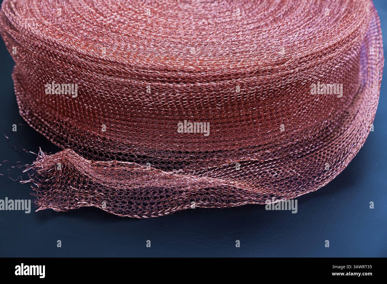 Copper mesh, twisted into a roll, close up. Twisted copper mesh. Stock Photo