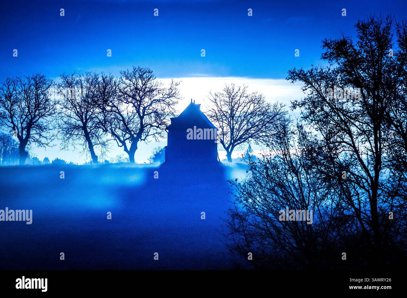 Silhouette of 'maison des vignes' (vine growers house or shelter) on hillside with rising sun behind - sud-Touraine, central France. Stock Photo