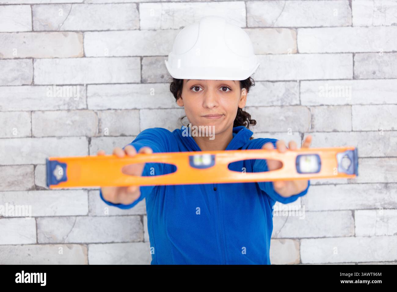 smiling female worker using a spirit level Stock Photo