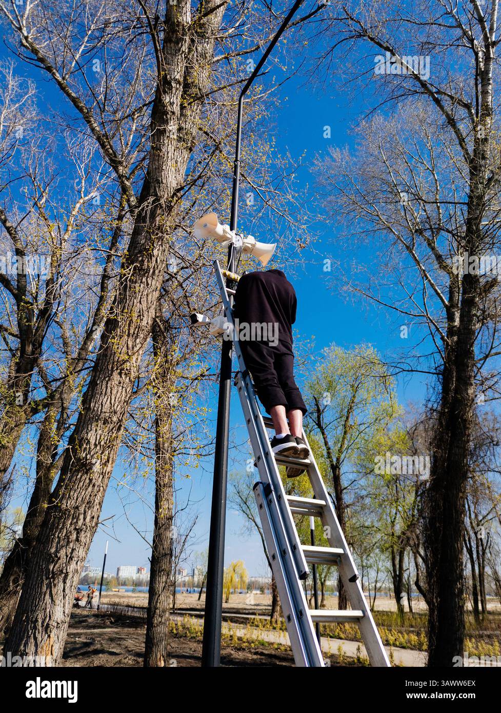 Worker installing security camera on lamp post. Stock Photo