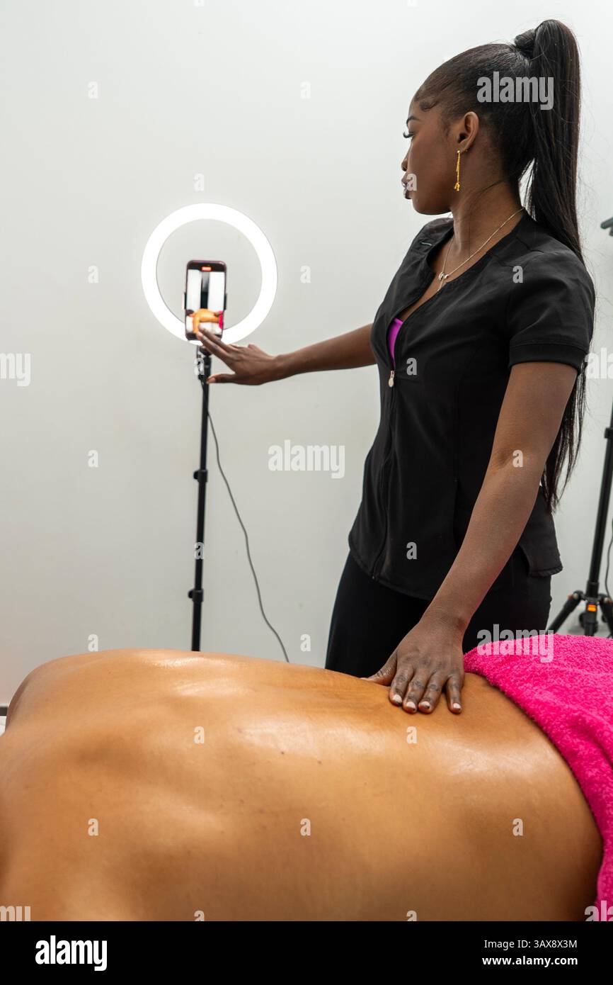 Masseuse recording online tutorial, streaming massage therapy techniques on social media Stock Photo