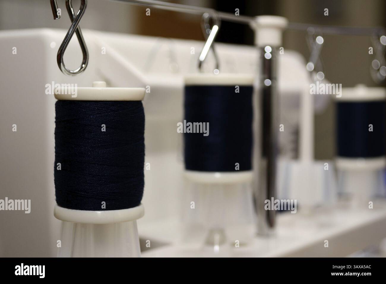 Black thread spools on sewing machine Stock Photo