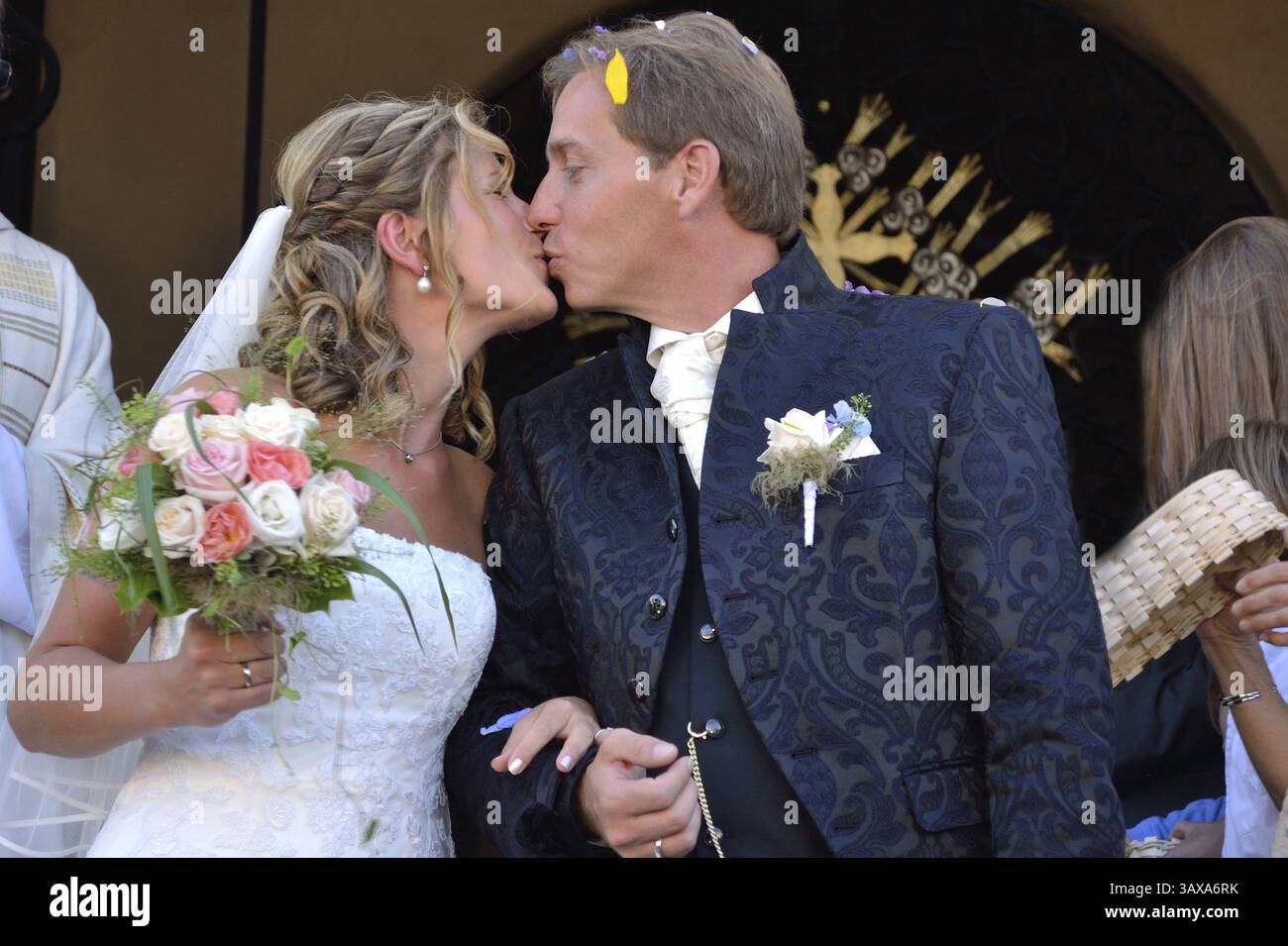 Newlyweds kiss in front of the church Stock Photo