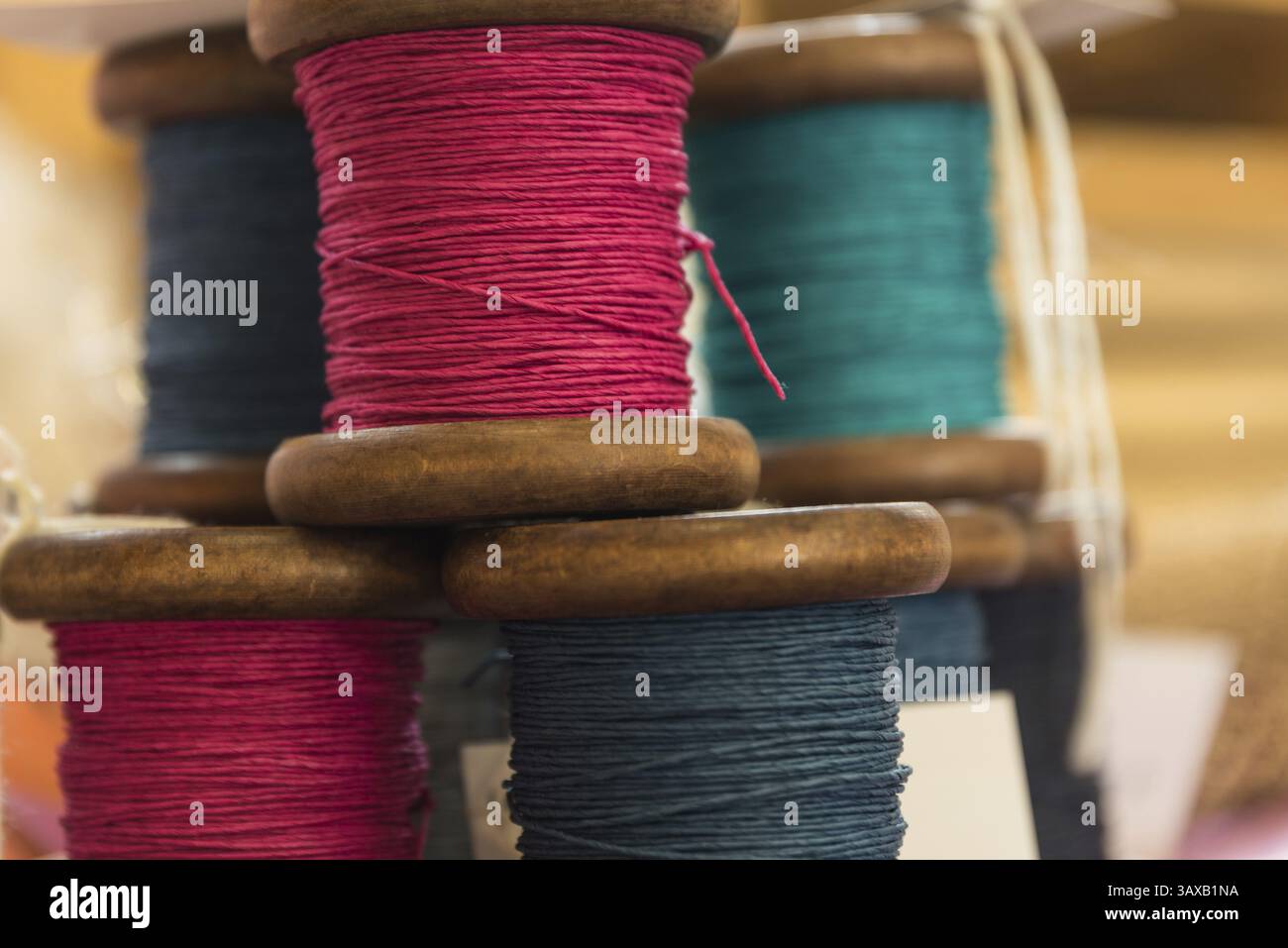 Coloured yarn wound onto wooden spools - thread and string Stock Photo