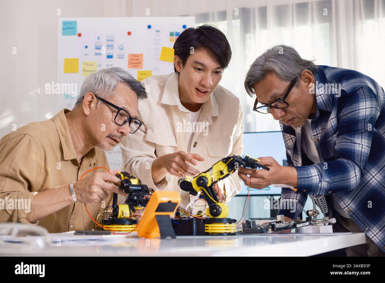 asian Robot arm engineers brainstorming in workshop to develop control ...