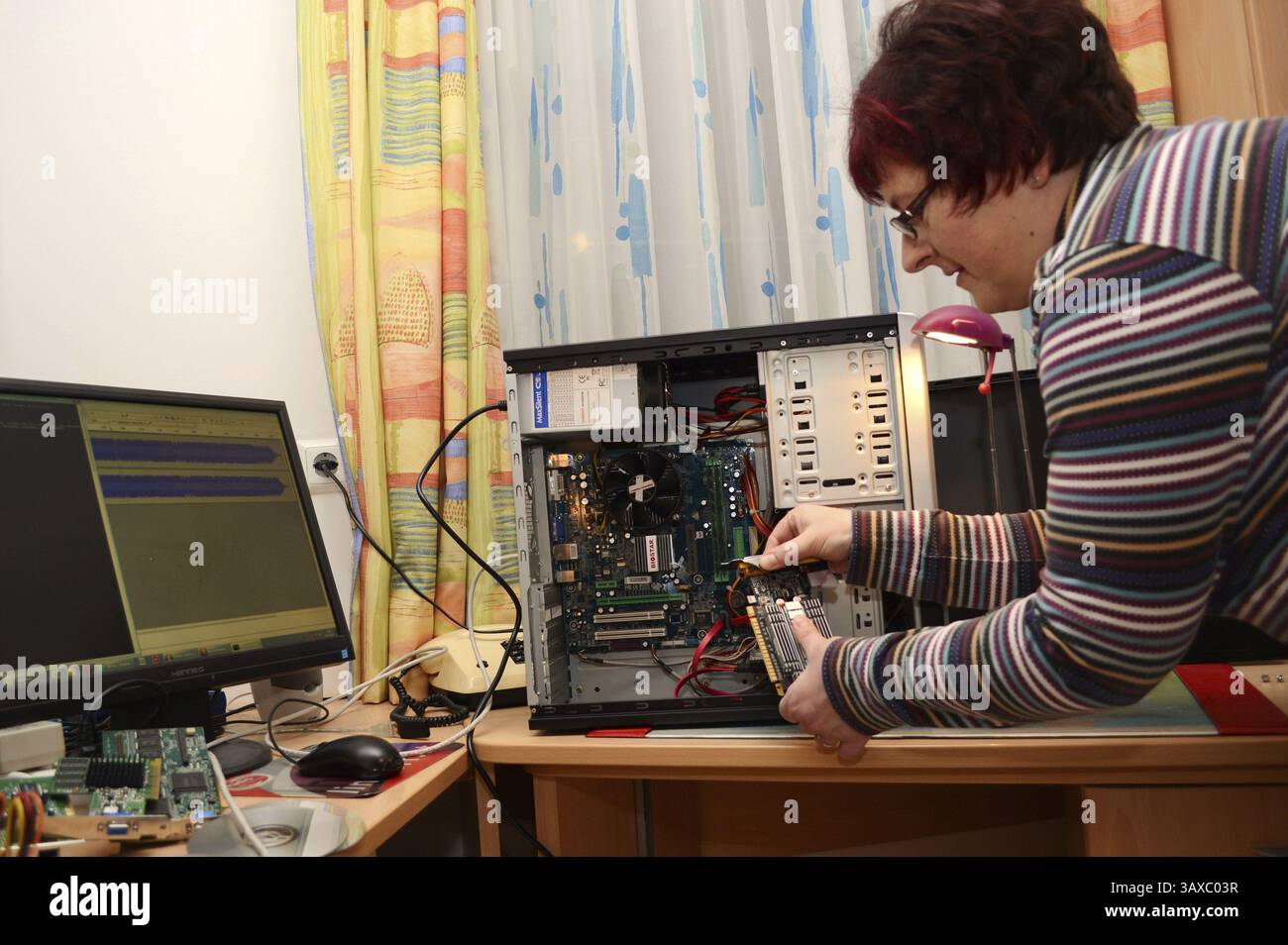 IT technician replaces the graphics card of a PC Stock Photo