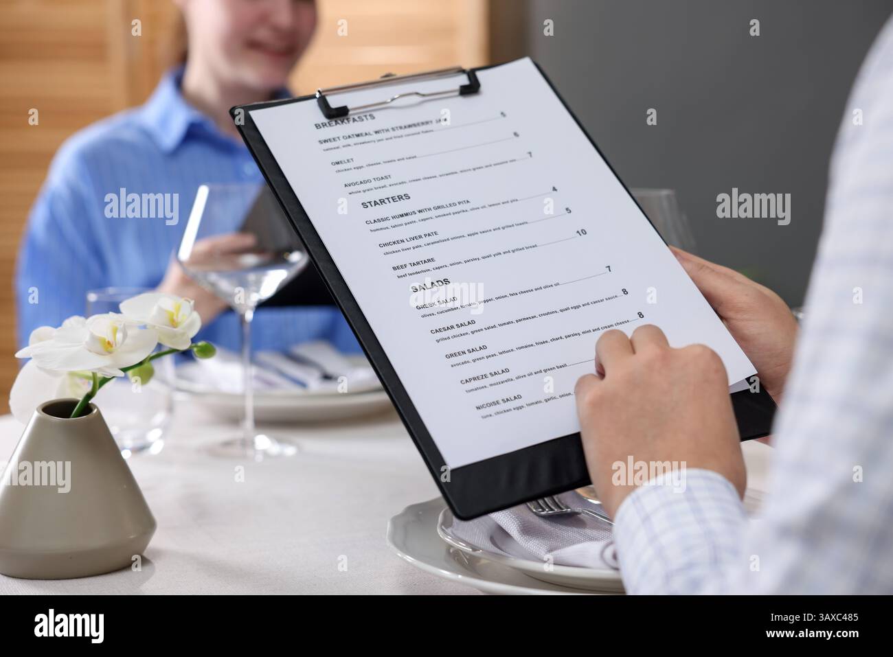 Couple choosing dishes from menu at table in restaurant, closeup Stock ...