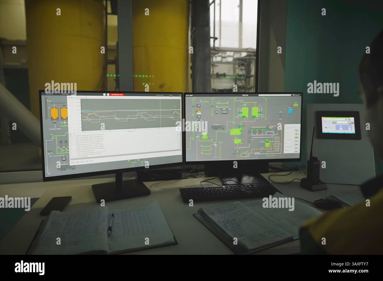The operator at the monitors observes the technological process Stock Photo