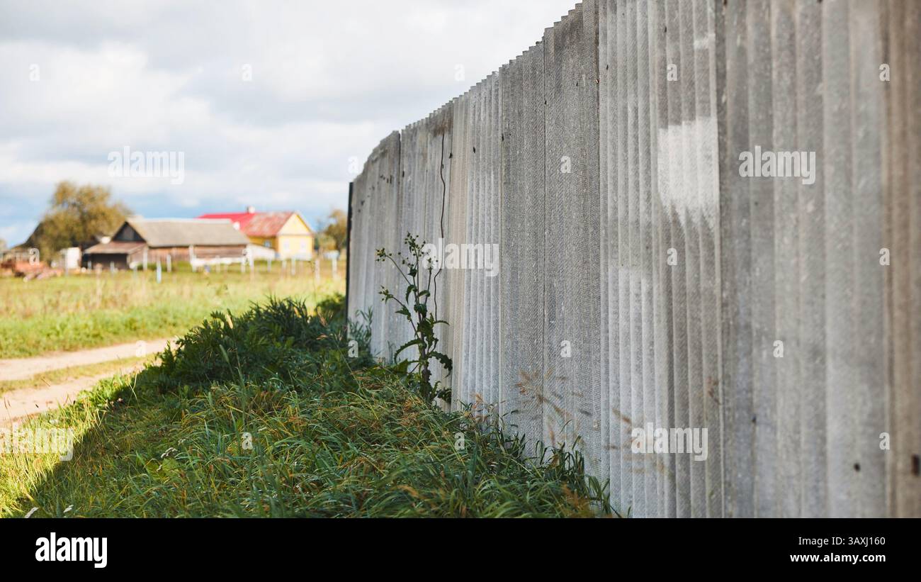 Rustic Boundaries Weathered slate wall edging rural dirt path, defining boundary between ...