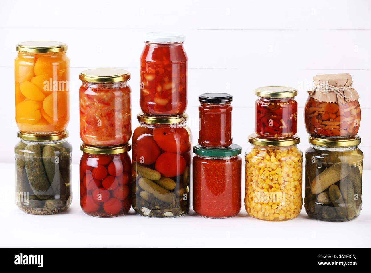 Many jars with different pickled products on white table Stock Photo