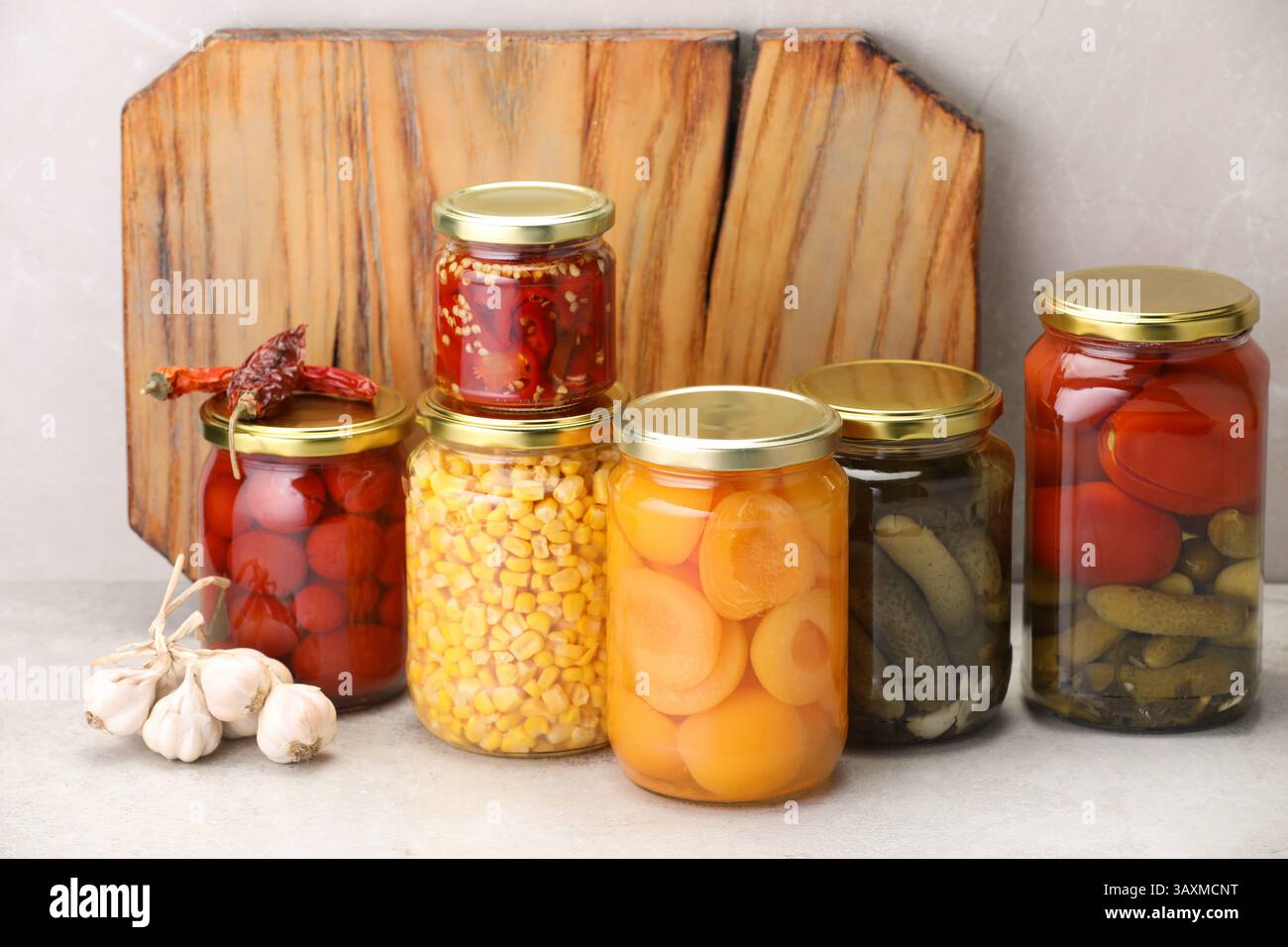 Many jars with different pickled products on light table Stock Photo