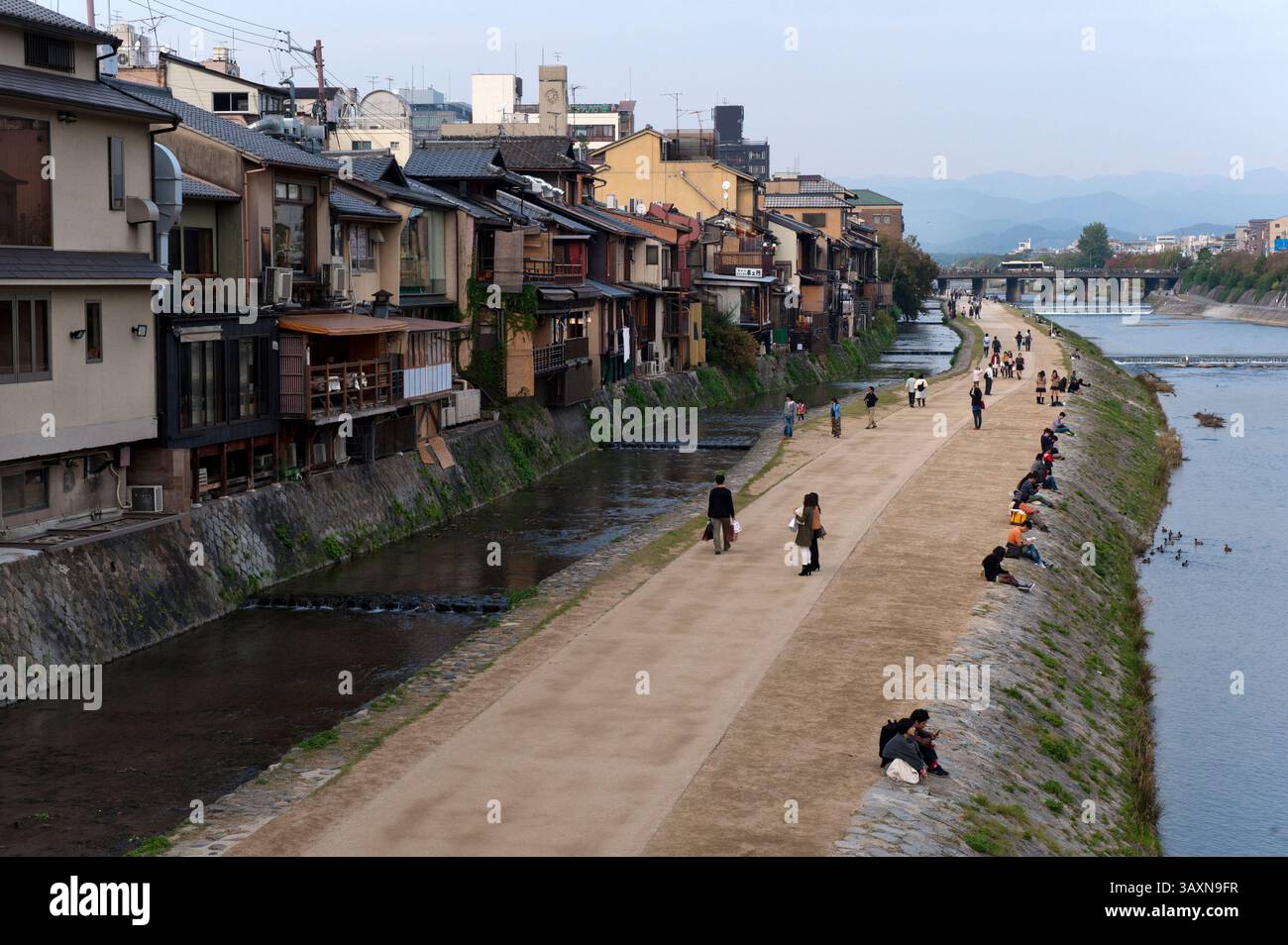 View along the Kamogawa (Kamo River) with Japanese couples sitting and ...