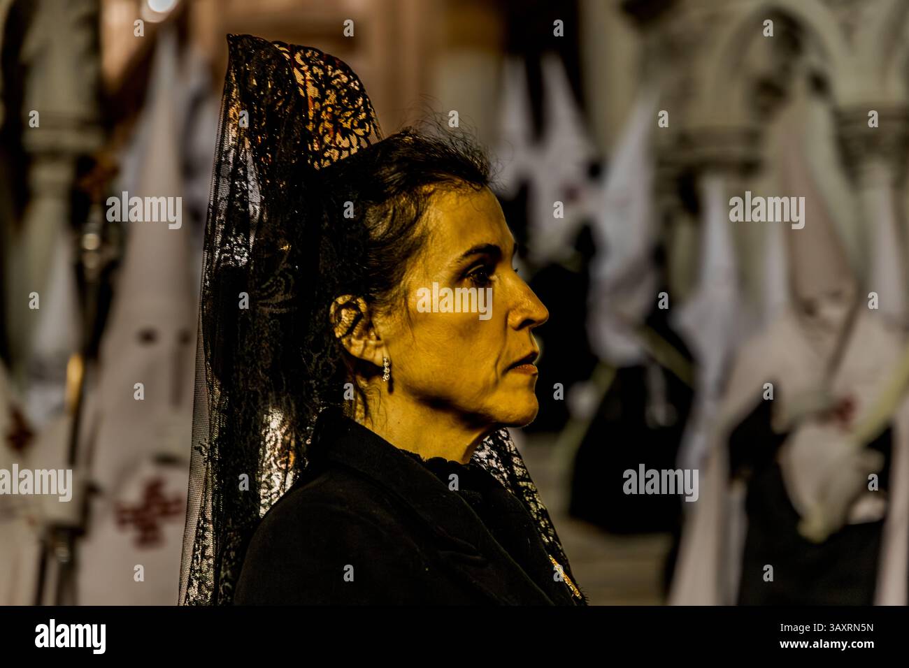 The evening Good Friday procession, which begins at 9 pm at Cuenca Cathedral, is characterised by special solemnity, silence and an impressive atmosphere. The mourning women with veil and mantilla (Manolas) show the connection between the biblical events and life today: they express the compassion and sympathy of the community and create a bridge between religious tradition and the personal experience of grief and hope. Calle San Pedro, Cuenca, Castilla-La Mancha, Spain Stock Photo