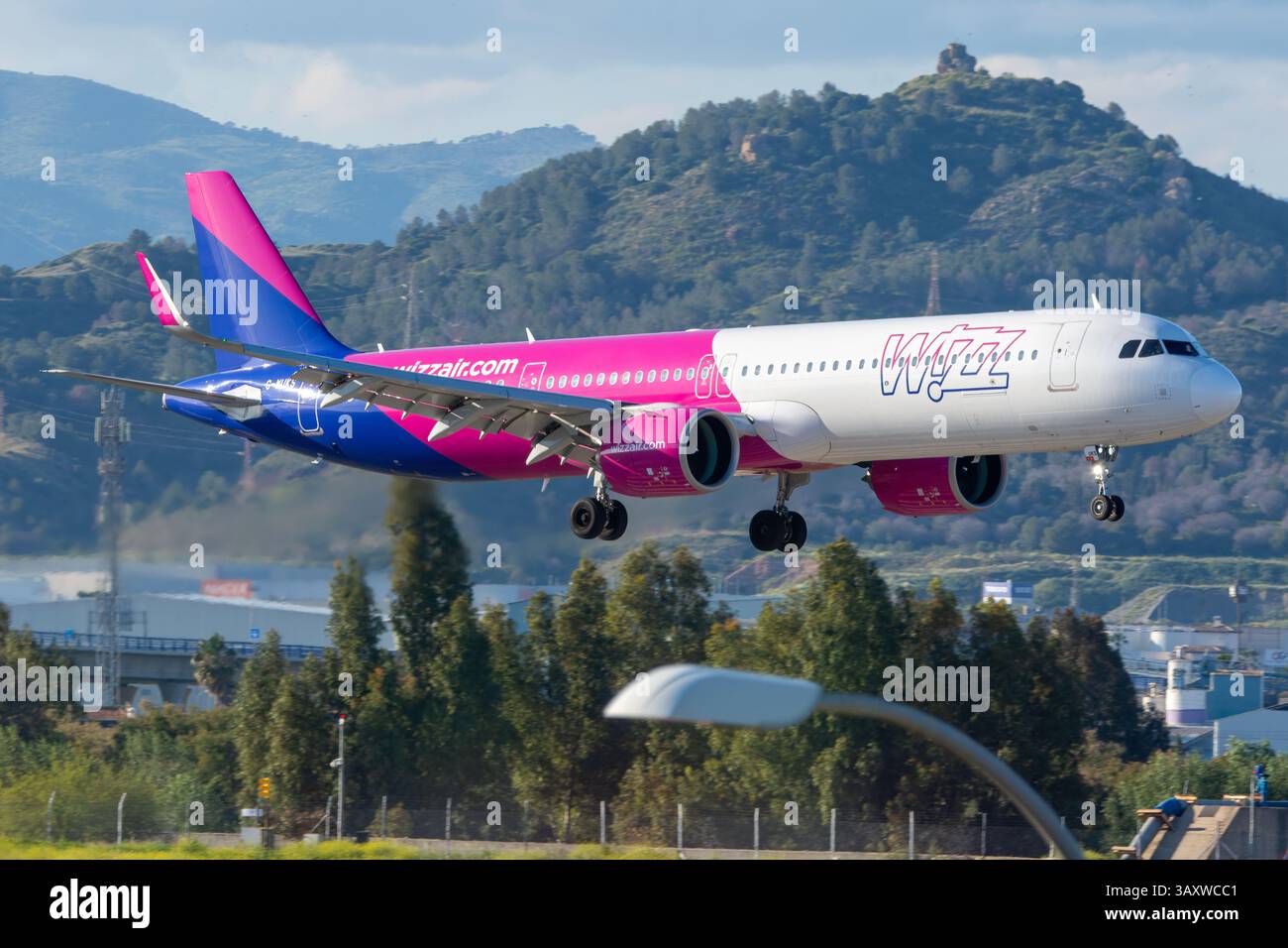 An Airbus A321 airliner from the UK-based airline Wizz Air UK lands at Málaga Costa del Sol Airport. Stock Photo