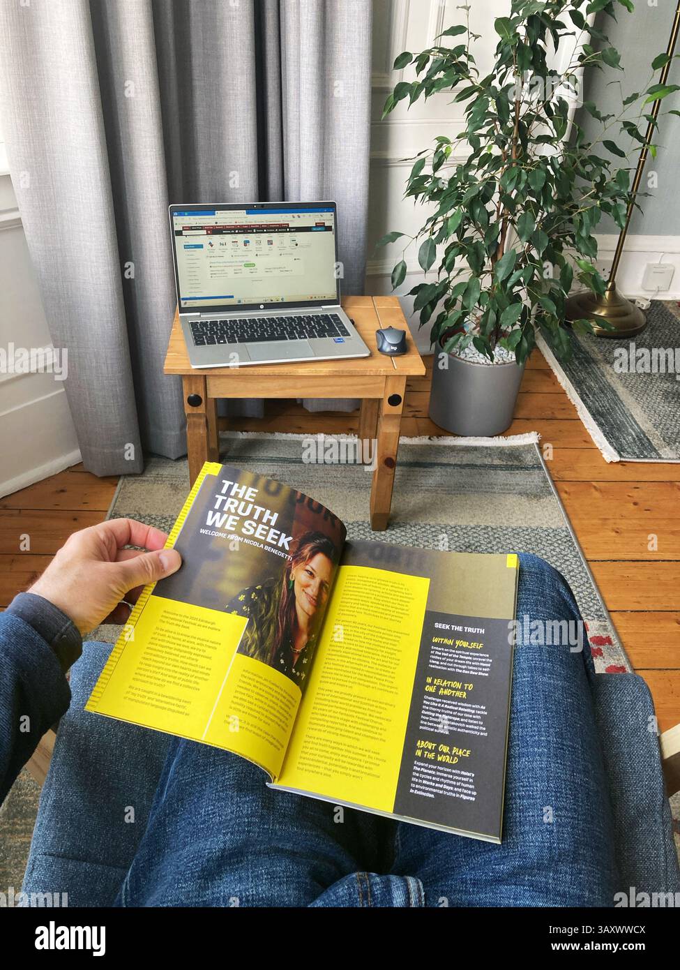 Browsing through the Edinburgh International Festival programme at home, paper copy for 2025, the festival dates are 1st–24th August 2025 - Smartphone Captured Stock Image